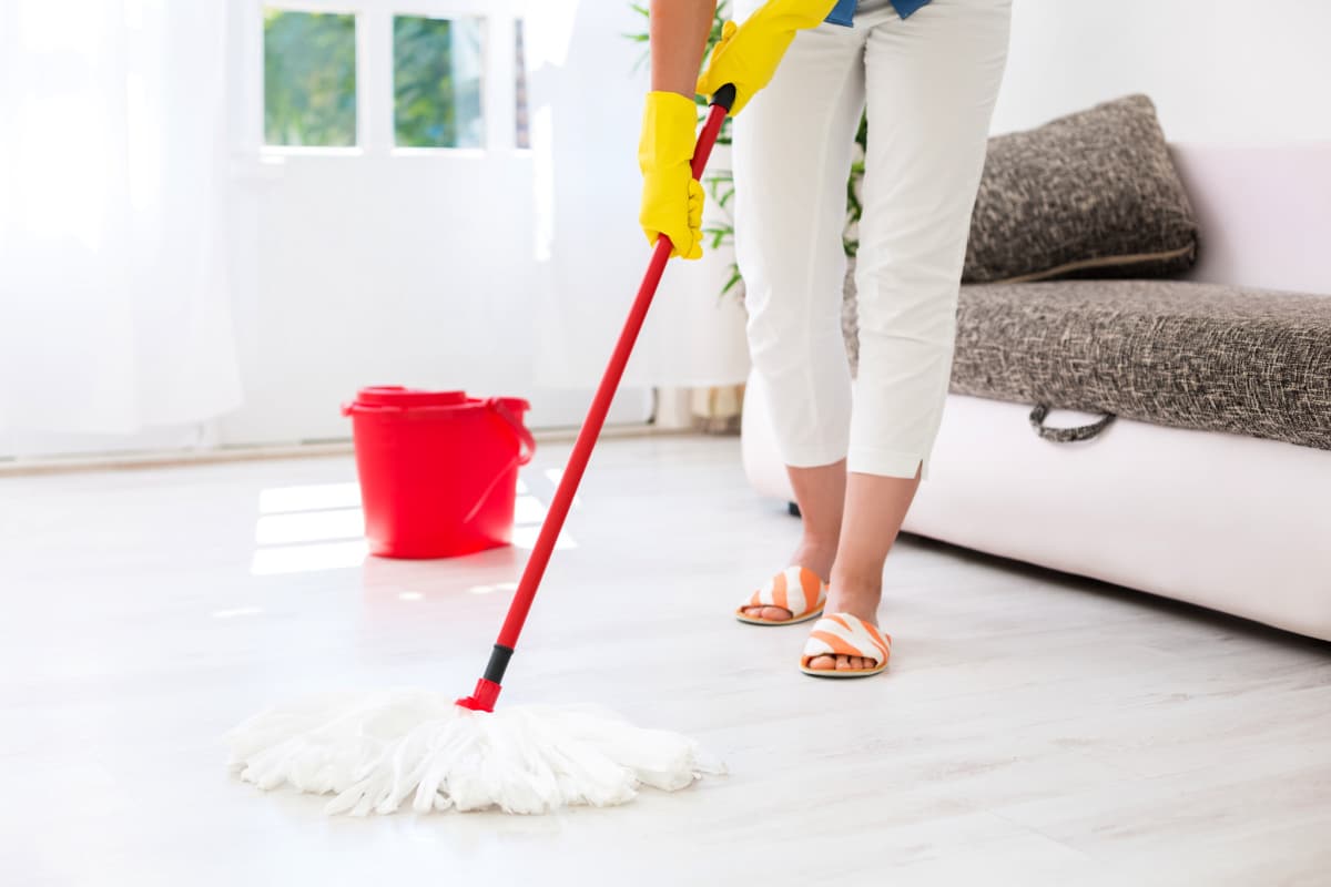 Lady cleaning her floor with a mop and bucket
